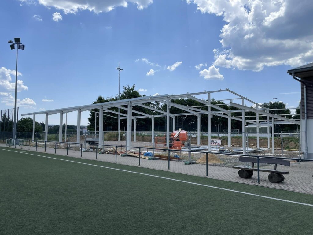 Das Bild zeigt den Rohbau der neuen Soccerhalle auf einem Sportplatz.